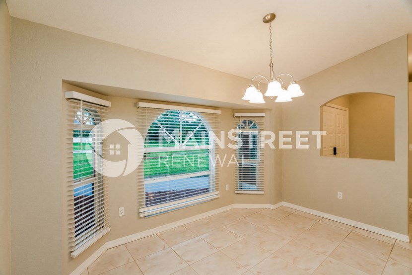 a living room with large windows and a tile floor