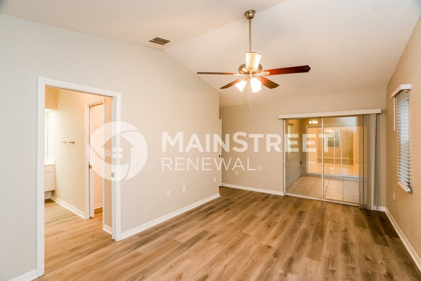a renovated living room with wood flooring and a ceiling fan