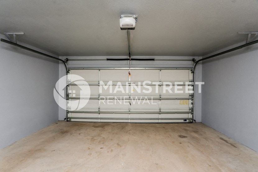 a room with a garage door and a wooden floor