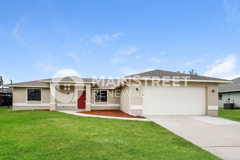 a renovated house with a garage and a lawn