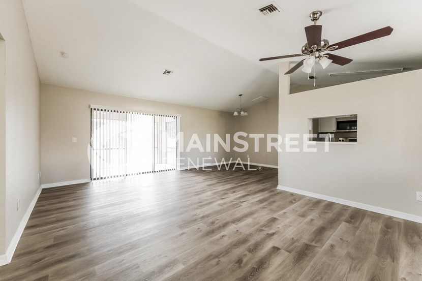 a living room with hardwood floors and a ceiling fan