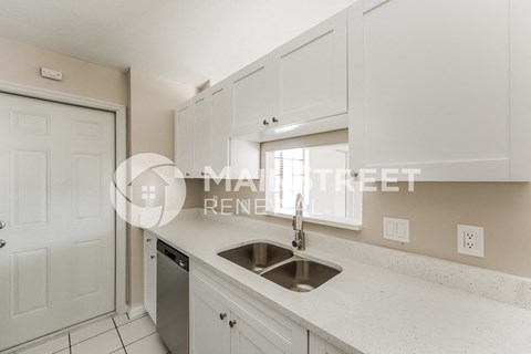 a kitchen with a sink and white cabinets