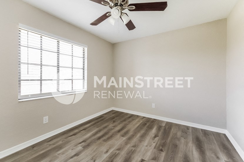 an empty room with a ceiling fan and a window