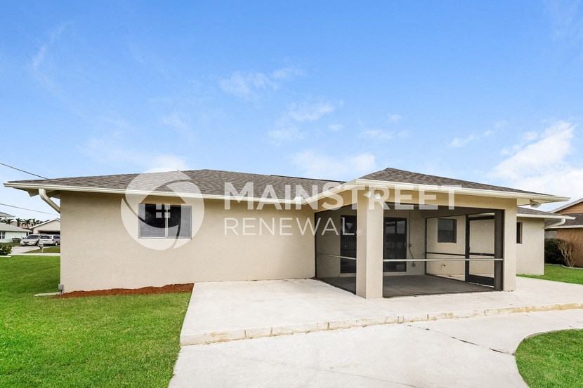 a small house with a garage and a lawn