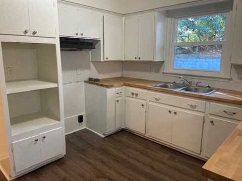 a kitchen with white cabinets and a sink and a window
