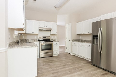 a kitchen with white cabinets and stainless steel appliances