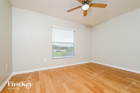 a living room with wood floors and a ceiling fan