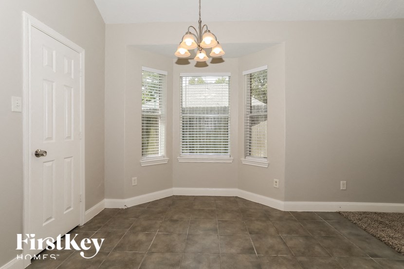 A room with a door, a window with blinds, and a light fixture.