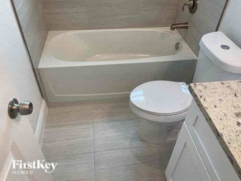 a bathroom with a toilet and a bath tub