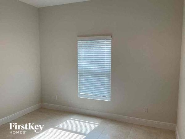 an empty room with a window and a tiled floor