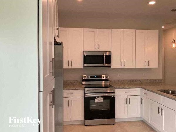 a kitchen with white cabinets and a stove and a refrigerator
