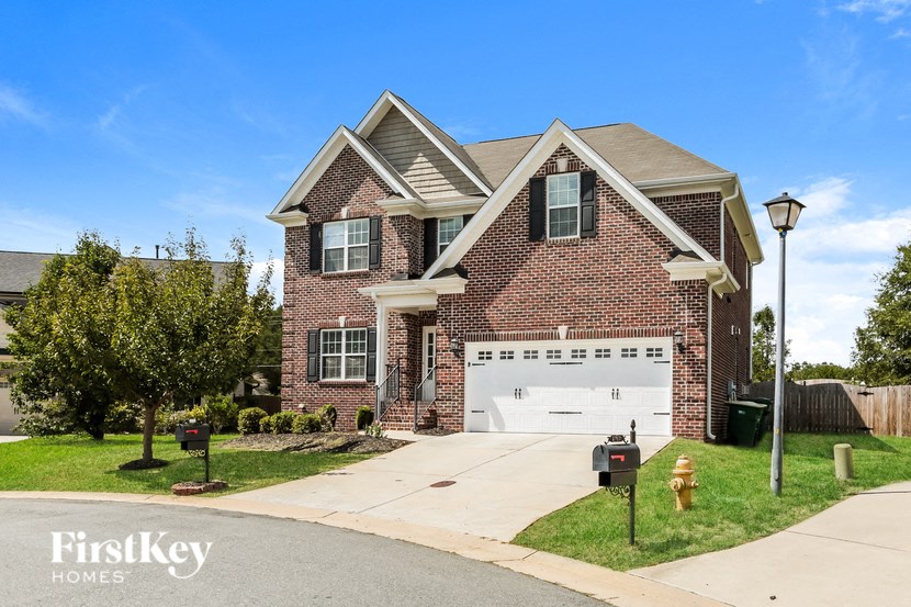 A brick house with a garage and a mailbox.