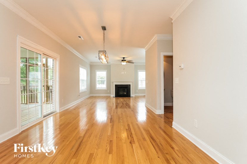 A spacious room with wooden floors and a fireplace.