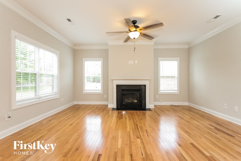 A spacious living room with a fireplace and hardwood floors.