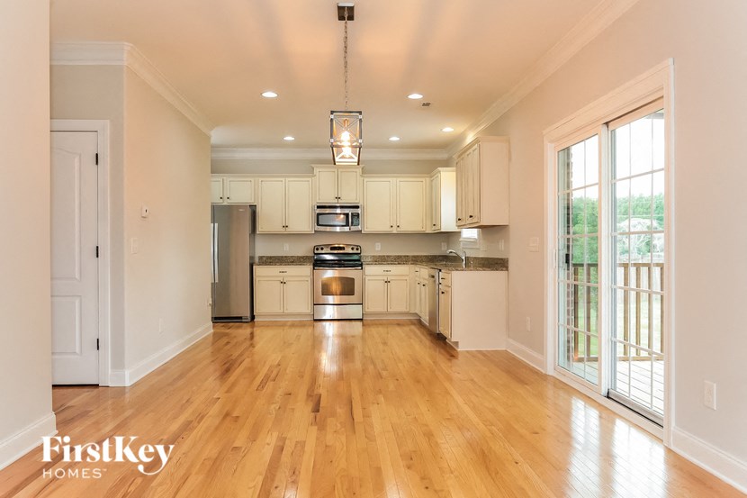 A kitchen with wooden floors and white walls.