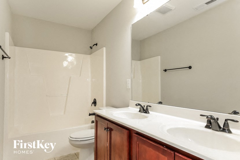 A white bathroom with a white toilet and a white sink.