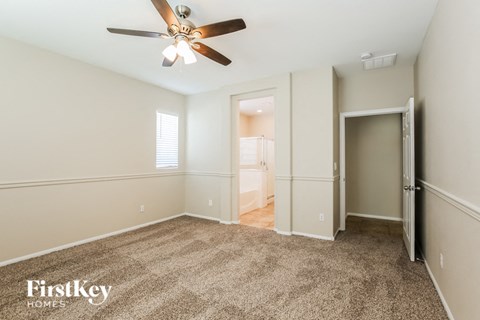 a living room with carpet and a ceiling fan