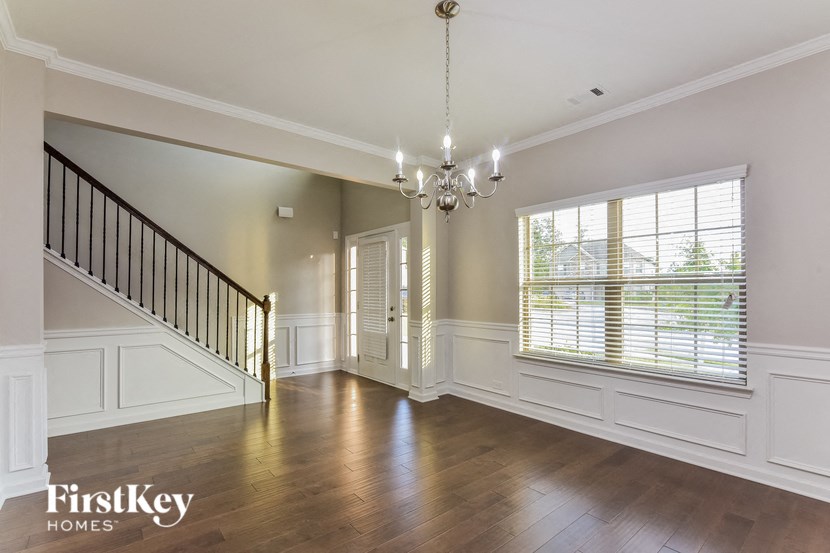an empty living room with a staircase and a large window