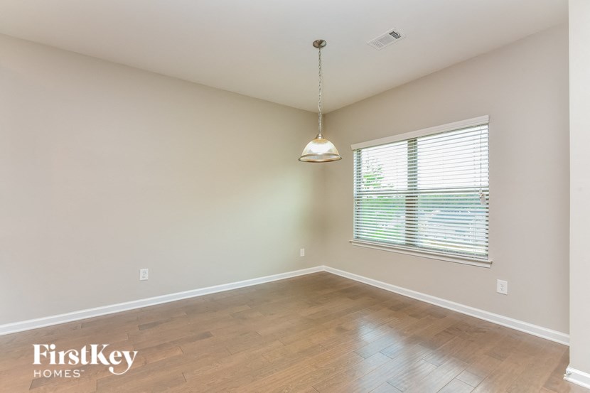 an empty living room with a large window and wood flooring