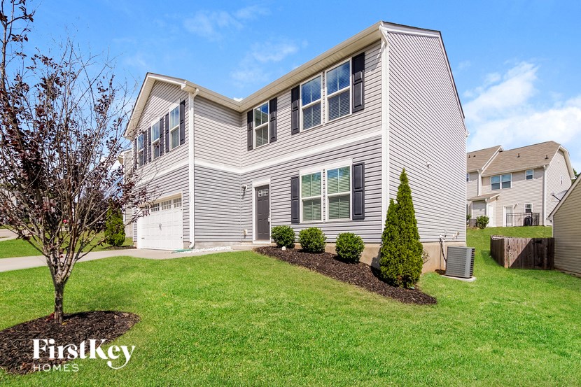 a white house with a lawn and trees in front of it
