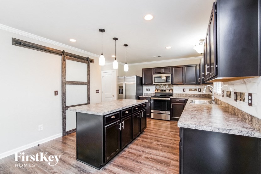 a kitchen with black cabinets and white countertops and a large island