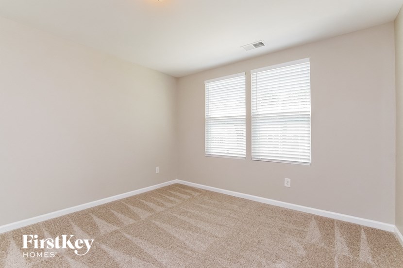 the living room of a new home with white walls and white window shutters