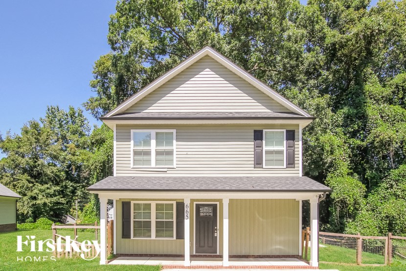 A house with a grey roof and a porch with a railing.