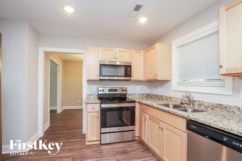A kitchen with wooden cabinets and granite countertops.