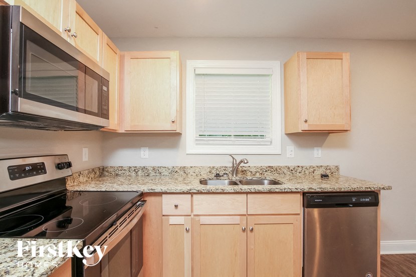 A kitchen with wooden cabinets and granite countertops.