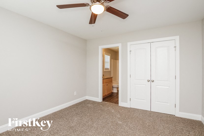 A room with a ceiling fan and two doors.