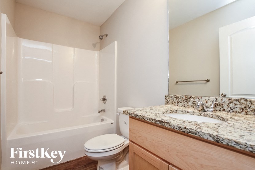 A bathroom with a toilet, sink, and bathtub.