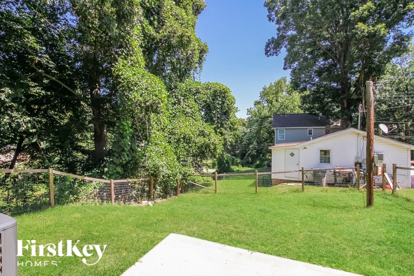 A backyard with a fence and trees.