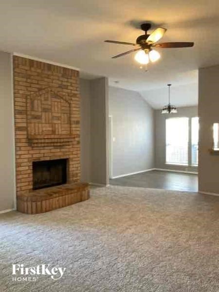A room with a fireplace and a ceiling fan.