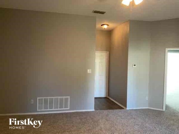 A room with a carpeted floor and a doorway leading to another room.
