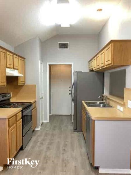 A kitchen with wooden cabinets and a refrigerator.