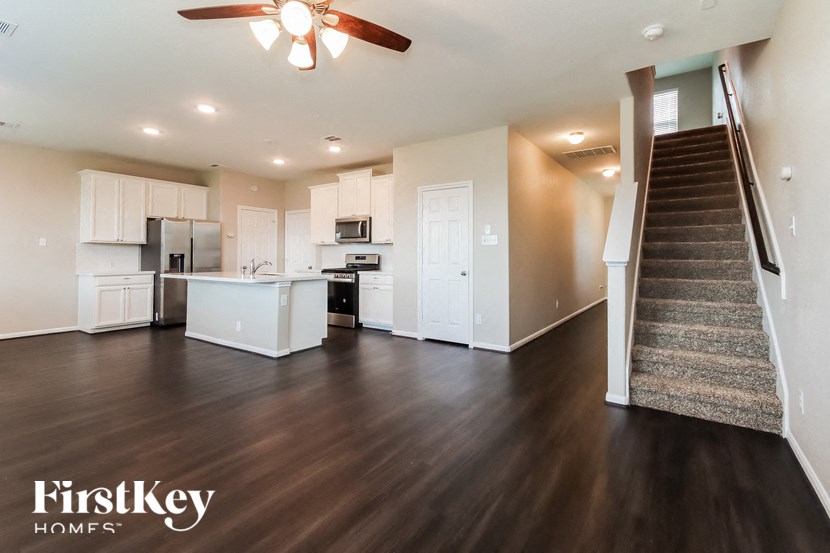 A spacious living room with a staircase leading to the upper floor.