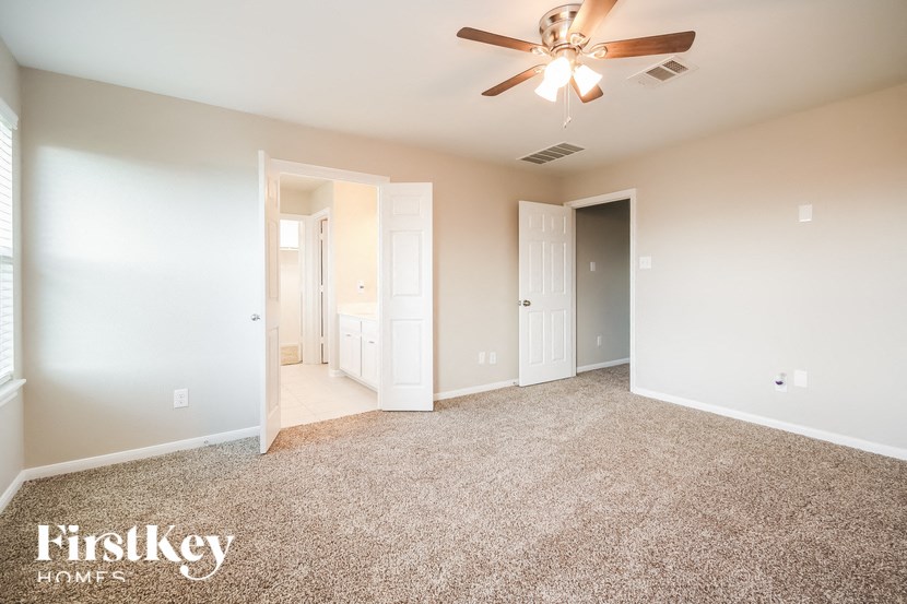 A spacious room with a ceiling fan and carpeted floor.