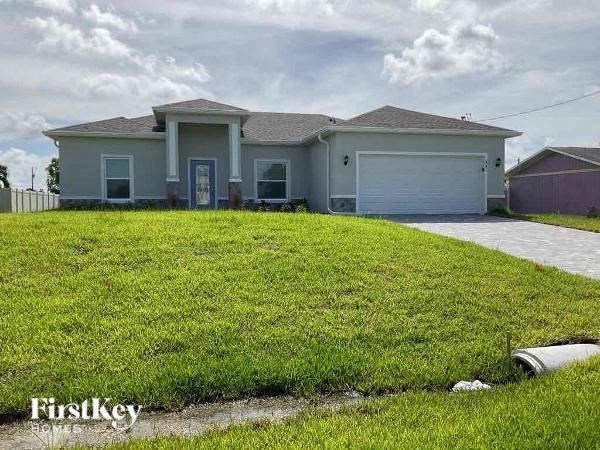 A house with a garage and a driveway in front of it.