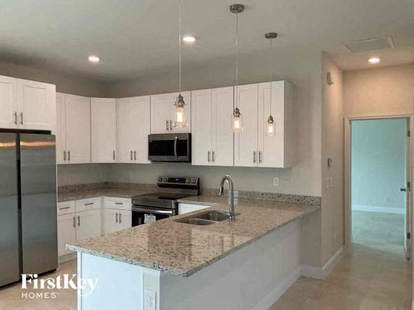 A kitchen with granite countertops and white cabinets.