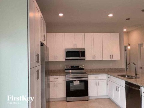 A kitchen with white cabinets and stainless steel appliances.