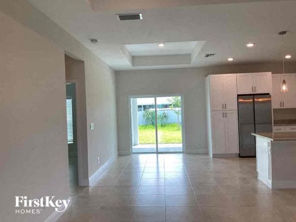 A spacious kitchen and living room with a view of the outdoors.