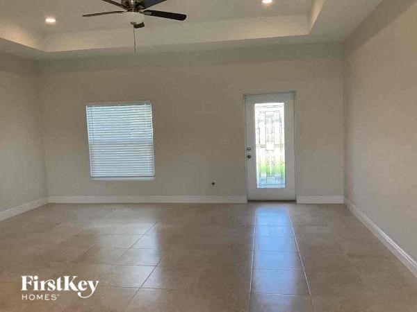 A room with a ceiling fan and a door leading to a balcony.