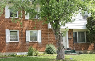 a brick house with a tree in front of it