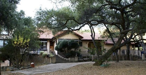 a house with stairs and trees in front of it