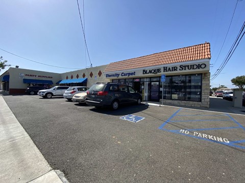 a hair salon with cars parked in front of it