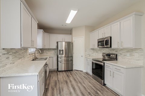 a kitchen with white cabinets and stainless steel appliances