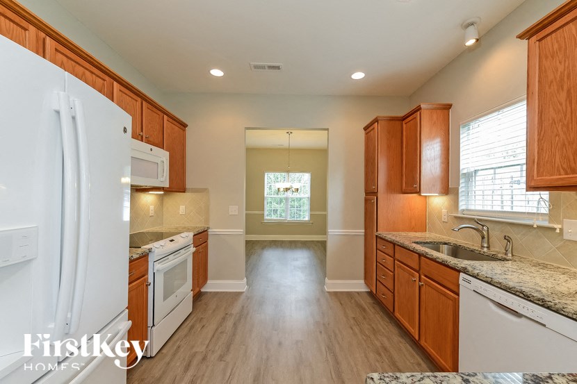 a kitchen with white appliances and wooden cabinets
