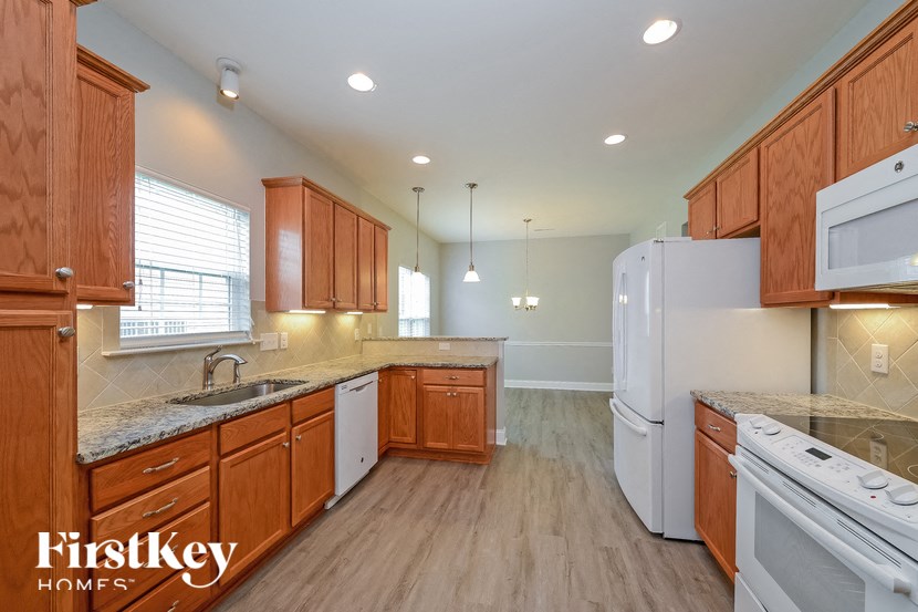 a kitchen with wooden cabinets and white appliances and a sink