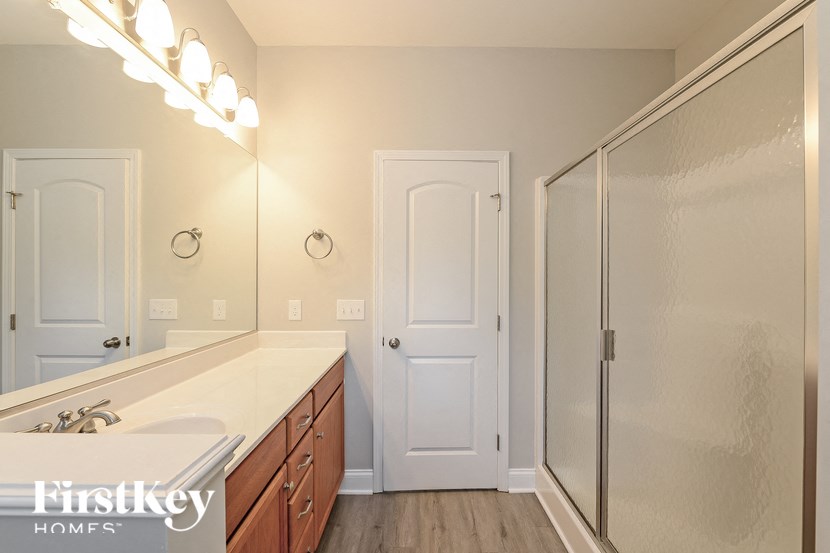 the master bathroom has a large vanity and a shower