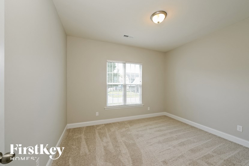 a spacious living room with carpet and a window